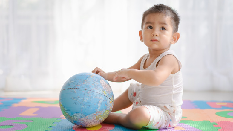 Baby boy playing with globe