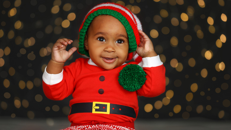 Baby boy smiling and touching hat