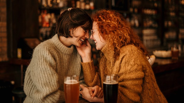 Two women cuddling in a bar