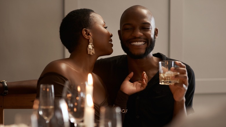 A cozy couple drinking whiskey