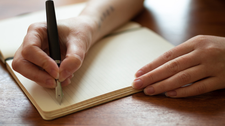 A woman writing in a journal 