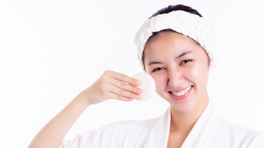 A woman applying skin toner to her face