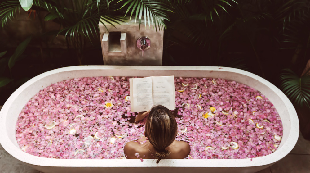 Woman reading in flower bath