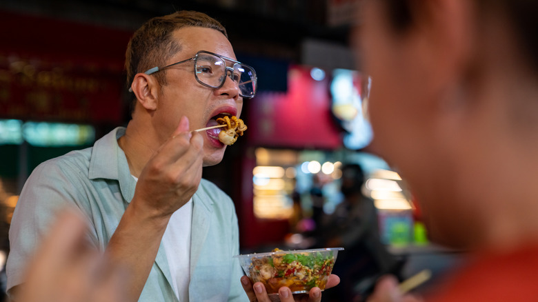 Man eating red pepper squid