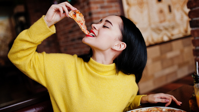 Woman enjoying slice of pizza