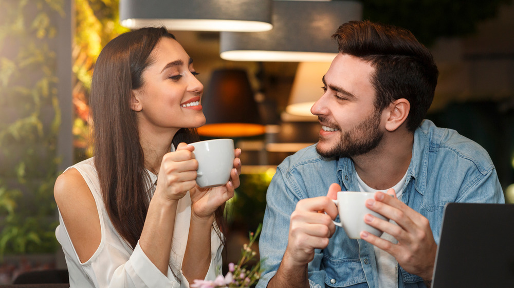 A couple smiling with coffee cups