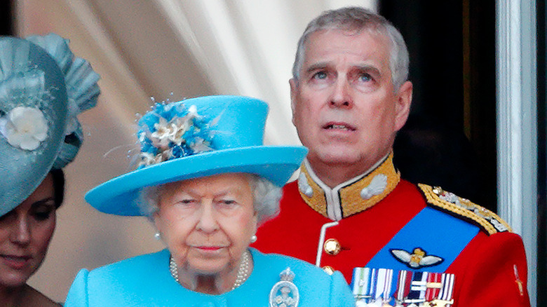 Prince Andrew looks worried behind his mother, the queen