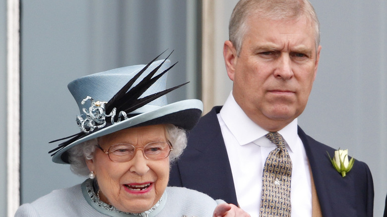 Prince Andrew stands behind his mother, the queen