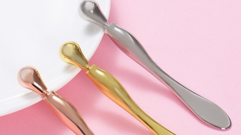 Skincare spoons on a pink background 