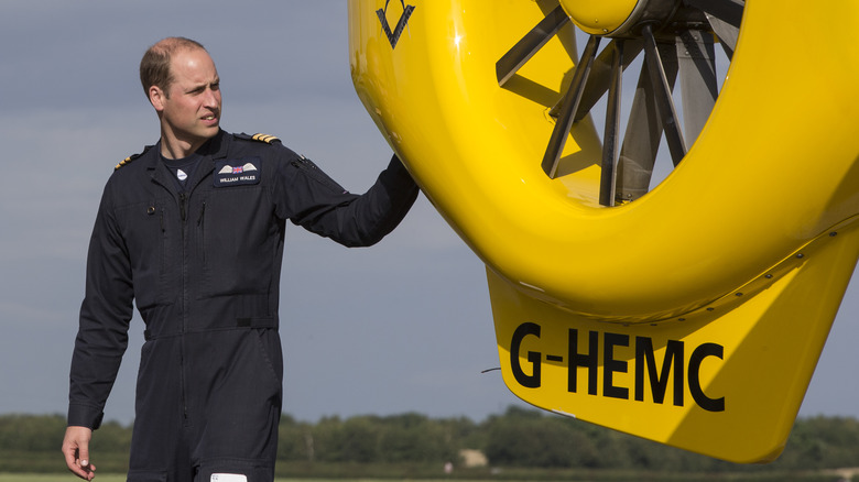 Prince William standing near a helicopter. 