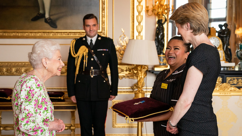 Queen Elizabeth smiling talking to George Cross award winners