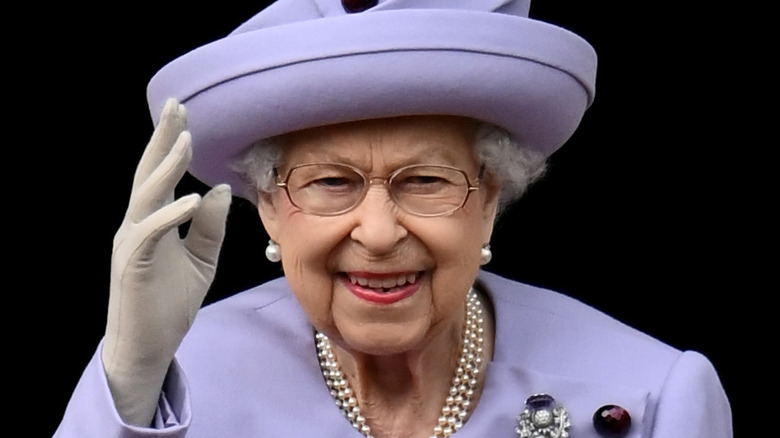 Queen Elizabeth smiling with arm raised