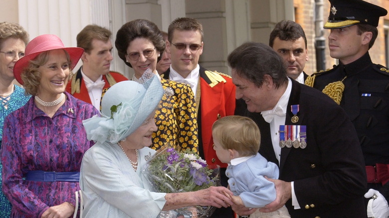 William hands the Queen Mother a baby