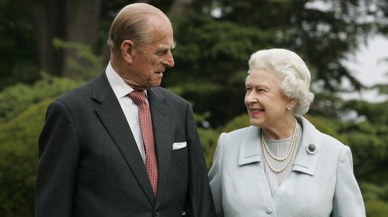 Queen Elizabeth and Prince Philip smiling at each other