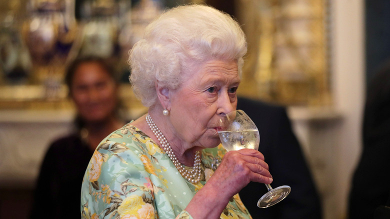 Queen Elizabeth drinking a glass of water