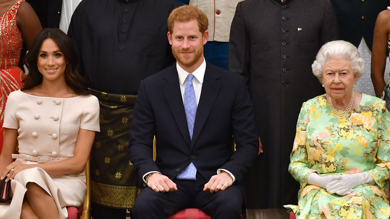 Meghan Markle, Prince Harry, and Queen Elizabeth sitting