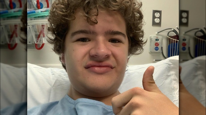 Gaten Matarazzo doing thumbs up from a hospital bed