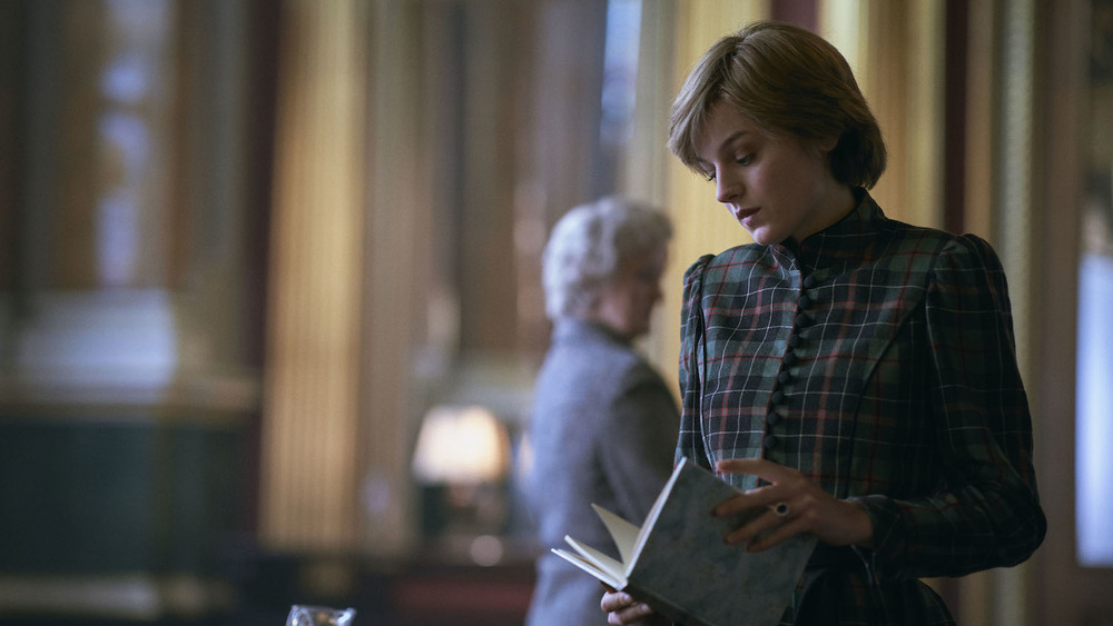 Emma Corrin in The Crown with a book