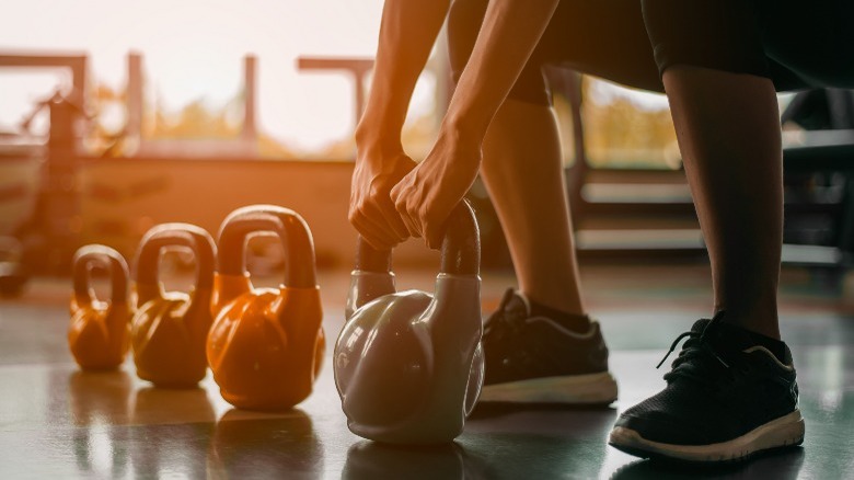 person lifting kettlebell at the gym