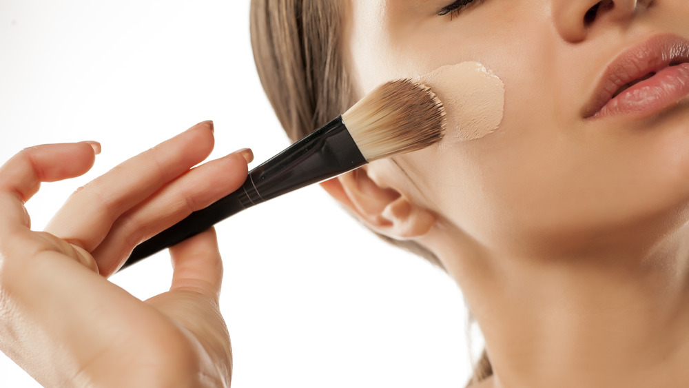 Woman applying liquid foundation