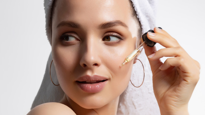 Woman holding serum to her face