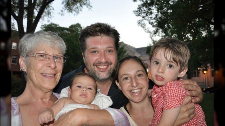 Susan, Lance, and Aliza Barber smiling while holding their kids