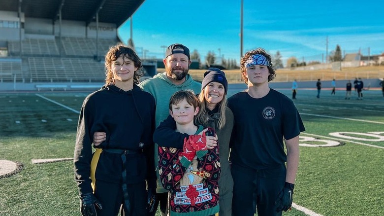 Leslie Davis posing with her husband and kids on a football field