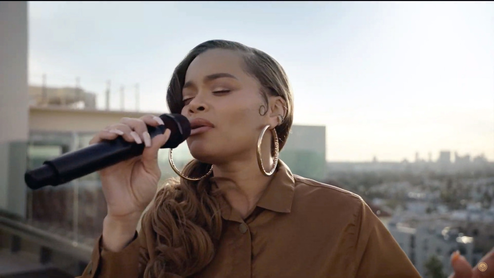 Andra Day singing in gold hoop earrings