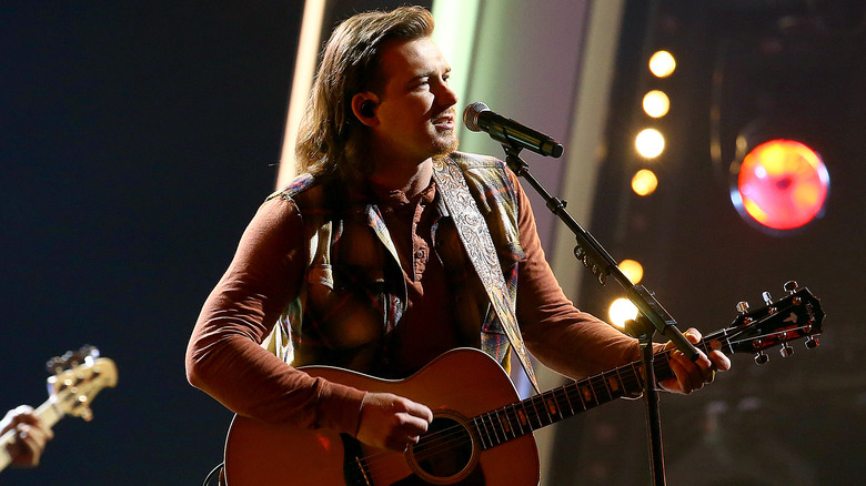 Morgan Wallen singing and playing guitar