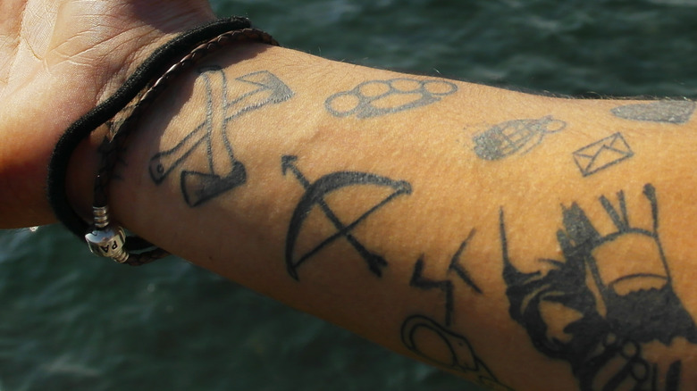 Tattooed arm with bow and arrow tattoo 