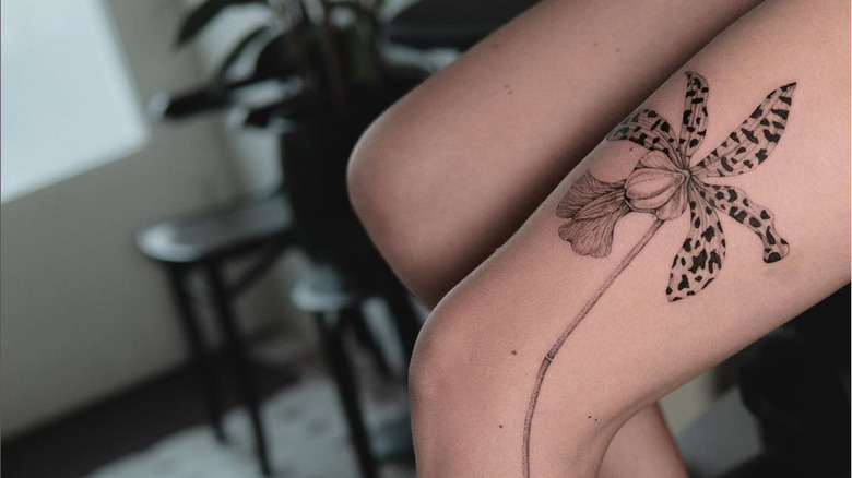 Orchid tattoo on someone's thigh