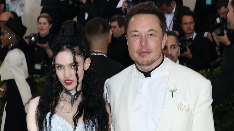 Elon Musk and Grimes posing for photos