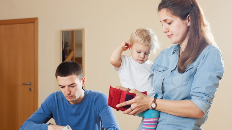 young family looking at bills and wallet