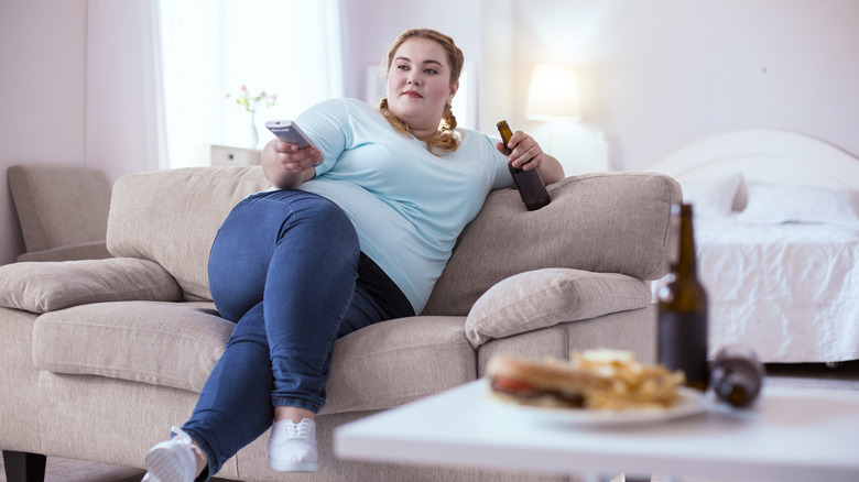 Woman drinking beer watching TV