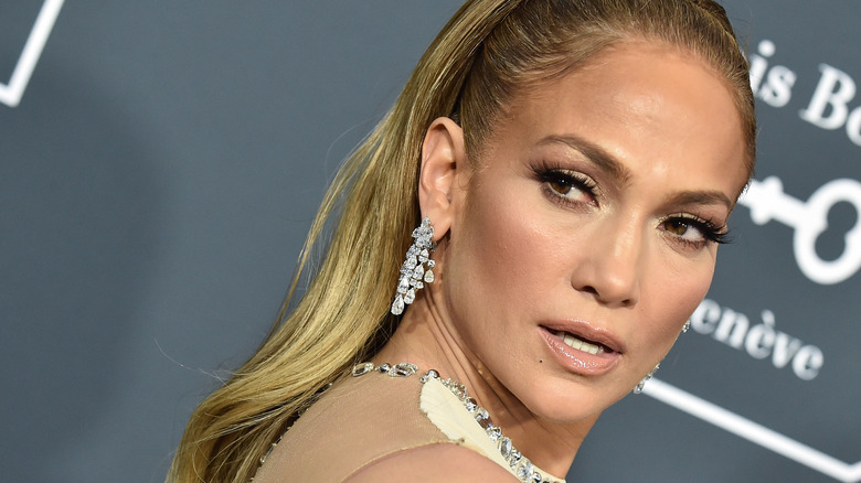 Jennifer Lopez looking back at a camera on a red carpet