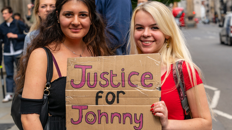 Fans hold signs for the Johnny Depp trial