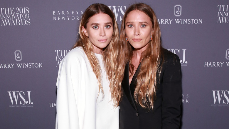 Ashley and Mary-Kate Olsen posing at event