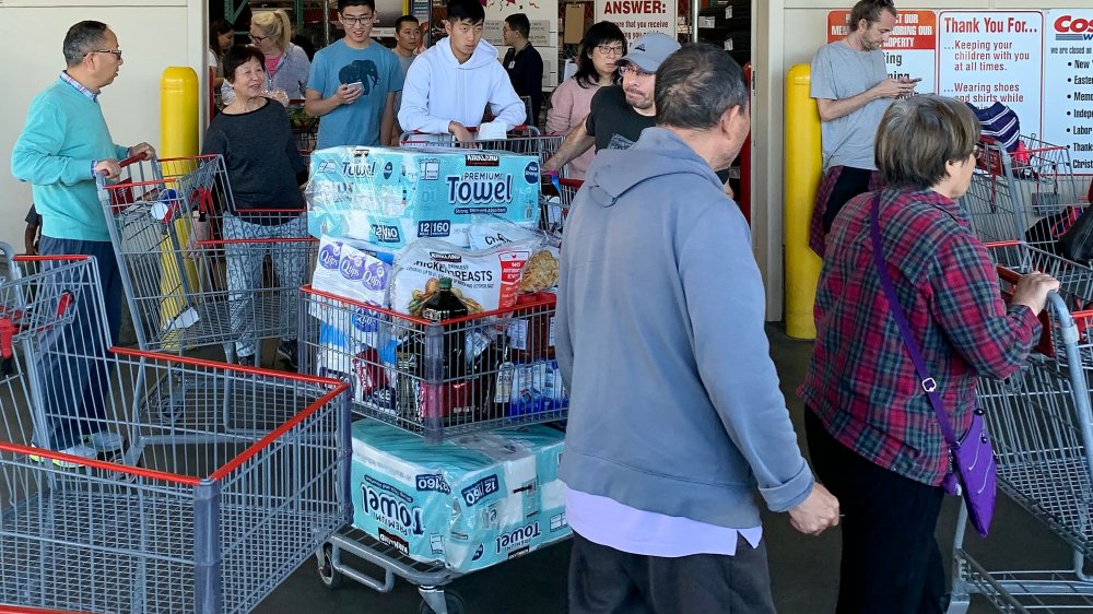 Shoppers whose carts are full of paper products