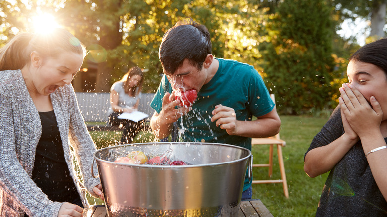 Man bobbing for apples