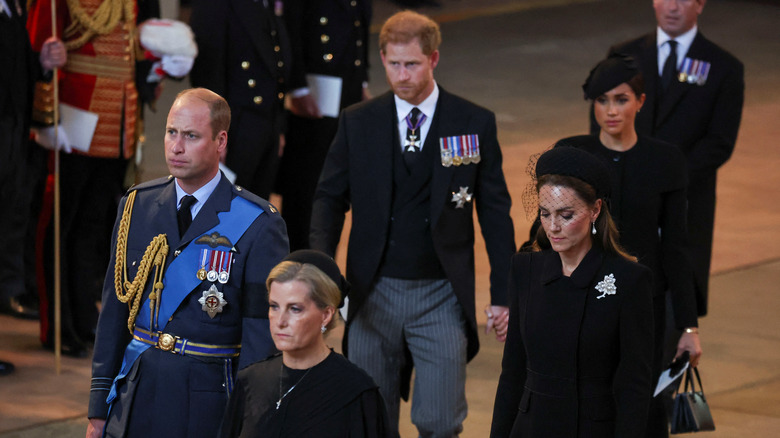 Prince Harry and Meghan Markle hold hands behind Prince William and Kate Middleton. 