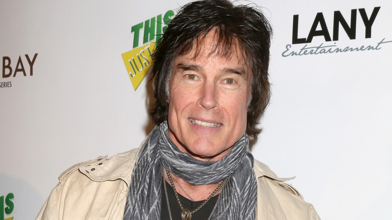 Ronn Moss smiling and wearing a scarf