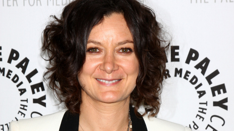 Sara Gilbert wears a white blazer with black liner.