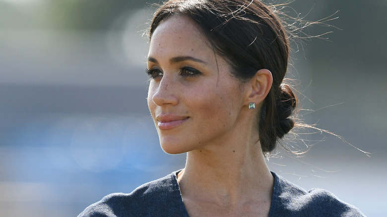 Meghan Markle smiling three-quarters profile