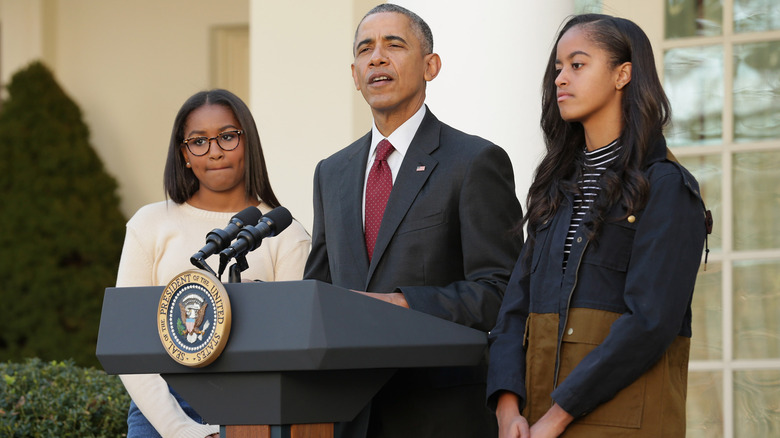 Barack Obama giving a speech with his daughters