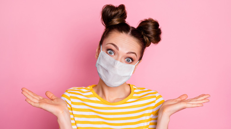 woman wearing face mask and looking confused