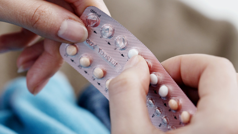 woman holding birth control pills