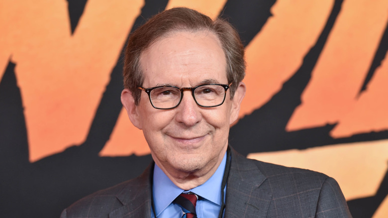 Chris Wallace smiles in gray suit