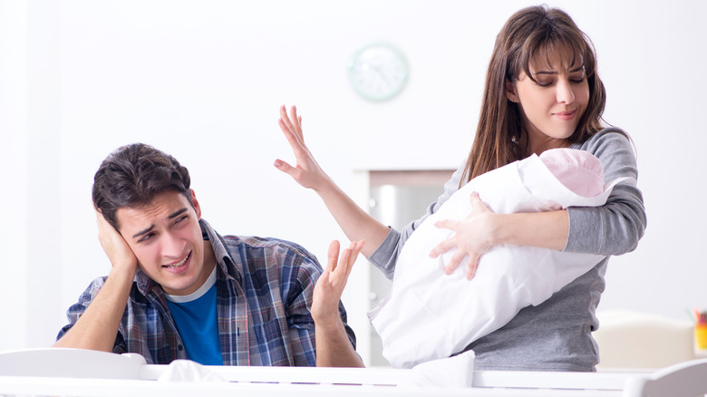 Mom taking care of baby while ignoring partner