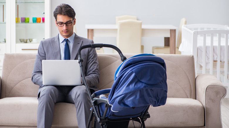 businessman on laptop while caring for baby