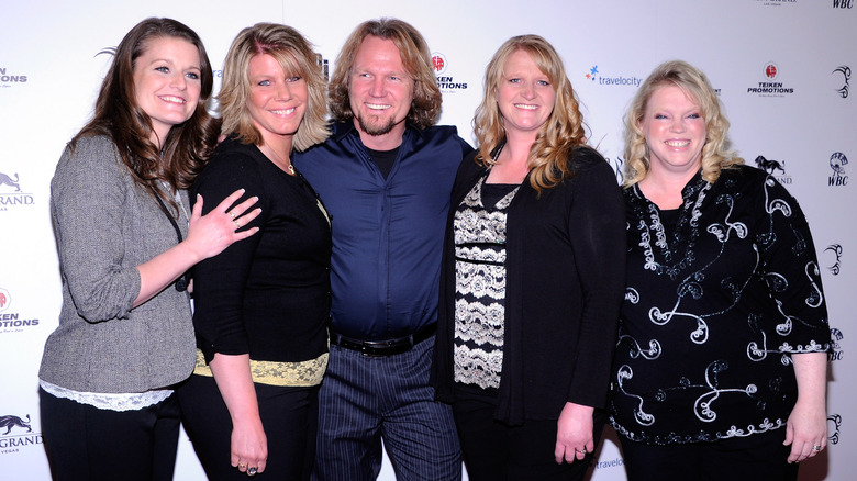 Sister wives posing with Kody brown at event